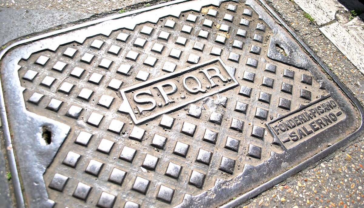 Manhole cover with "SPQR" inscription and "Fonderia Pisano -Salerno-" in Rome, Italy.